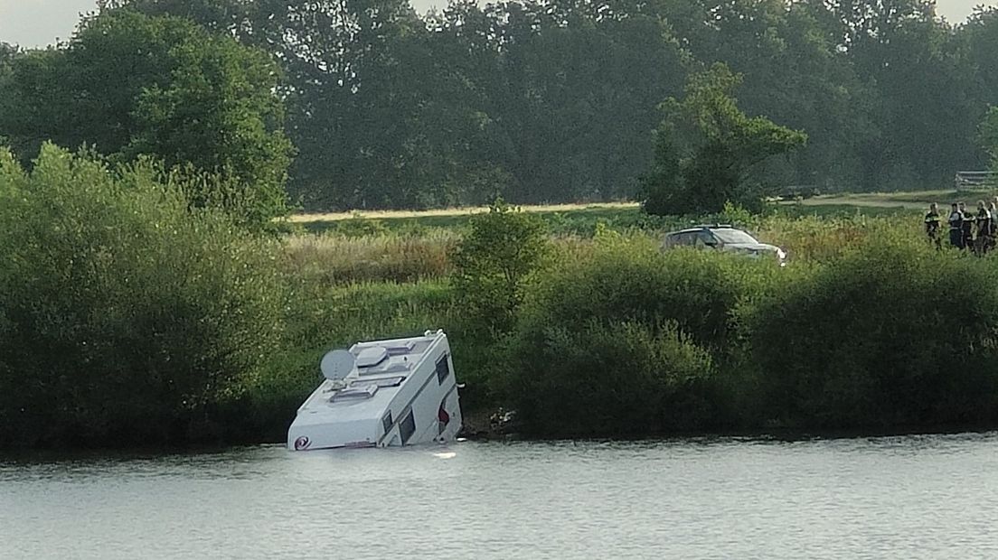 De camper is met de voorzijde in de Maas terecht gekomen