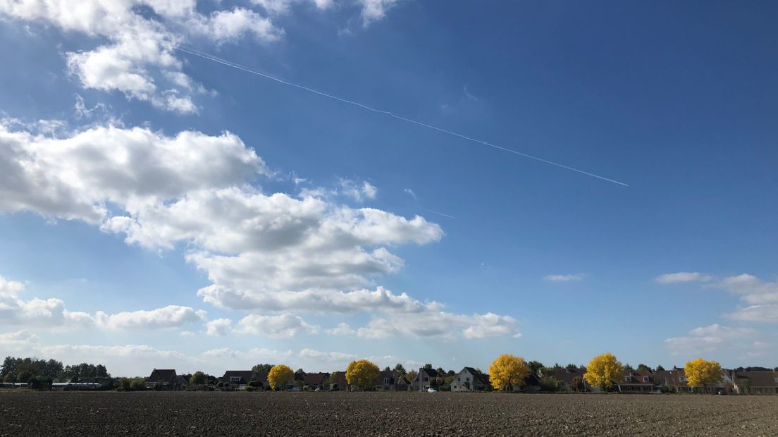 Zon, wolken, herfstkleuren en vliegtuigstrepen bij Kloetinge