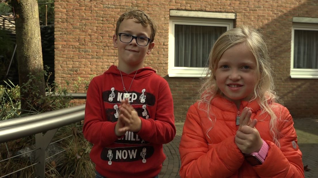 Kinderen ontsmetten hun handen in de dierentuin.