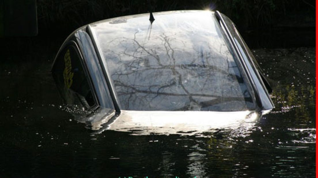 Man rijdt met auto kanaal in