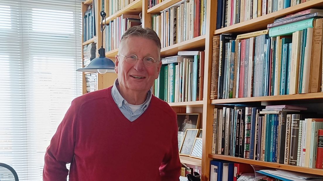 Kees Berenbak voor de boekenkast in zijn huis