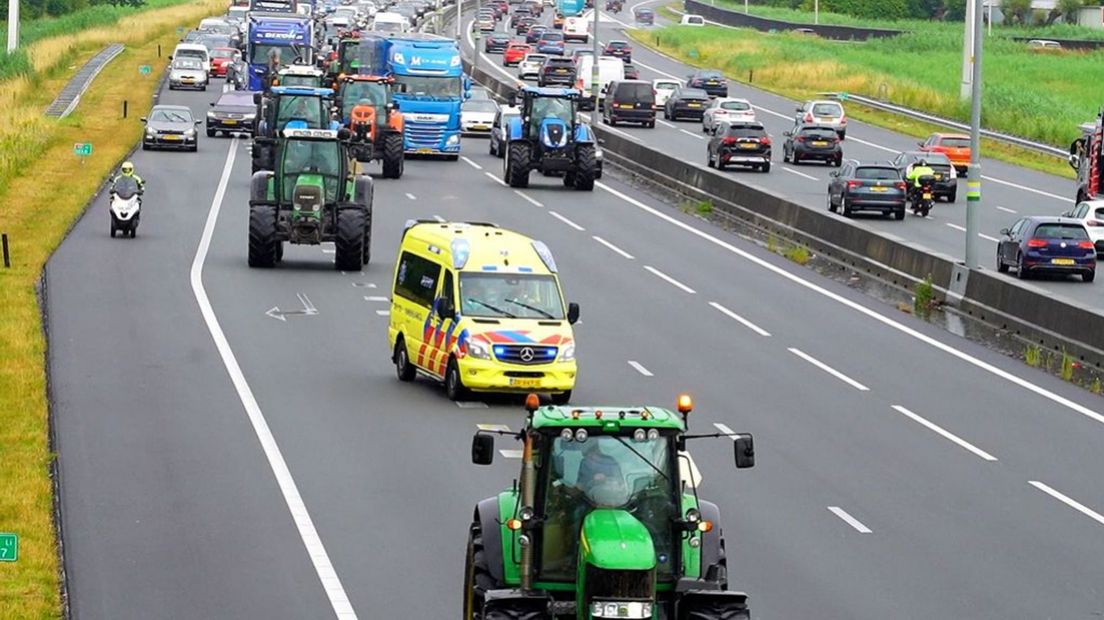 Een ambulance tussen de trekkers op de A12.