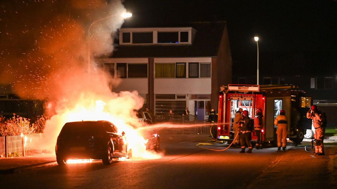 De brandweer blust de twee naast elkaar geparkeerde auto's in Hoogezand