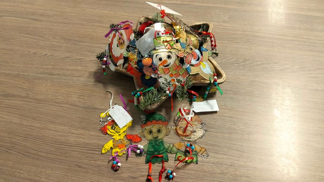 De kinderen van Kinderopvang Zeeuws-Vlaanderen hebben glazen kersthangers geverfd voor ouderen in IJzendijke