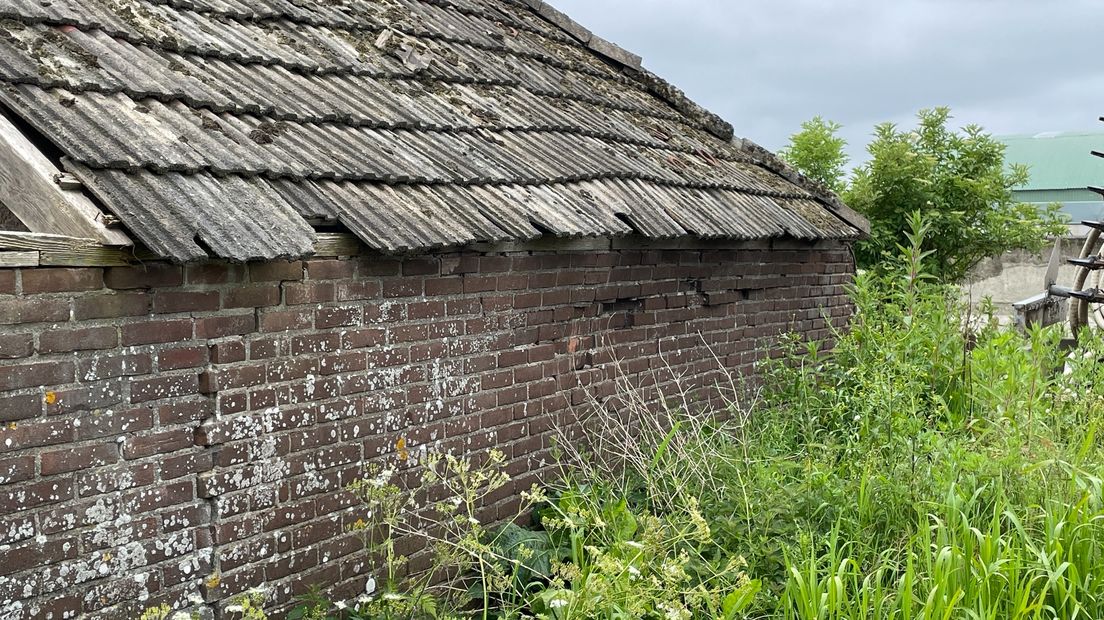 De muren van de oude boerderij verzakken en scheuren
