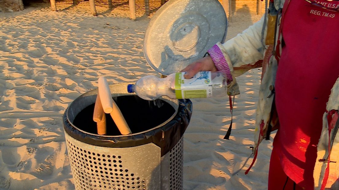 Een fles uit een vuilnisbak op het strand van Domburg