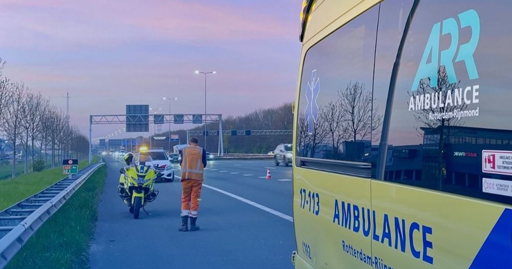 Ladderzatte vrouw staat op de vluchtstrook met hoofd op stuur - Rijnmond