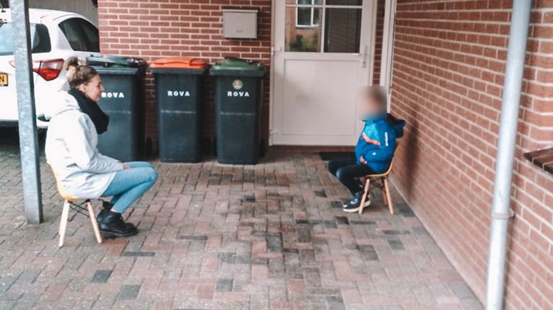 Juf Pien op stoepbezoek bij een van haar leerlingen