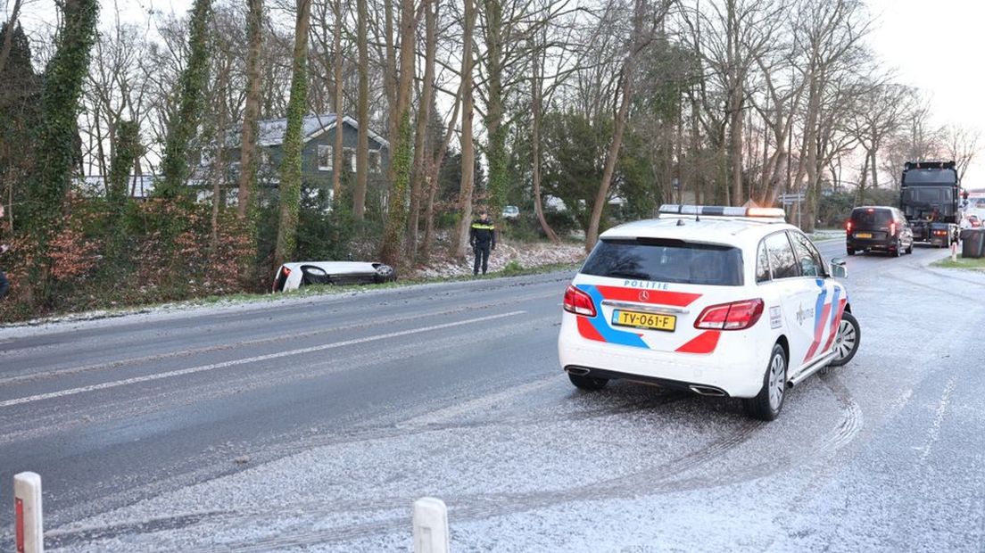 De wagen ligt op z'n kant in de sloot.