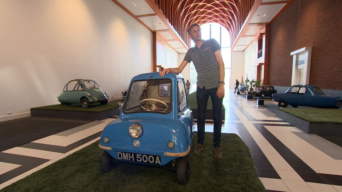 Verslaggever Rogier van der Zanden met naast hem een dwergauto.