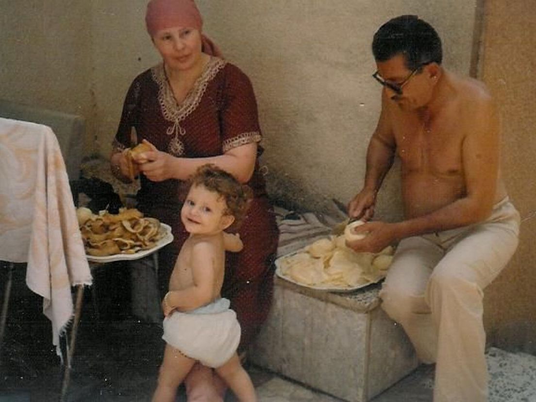 Hadil als baby bij haar opa en oma die aardappels schillen in Syrië.