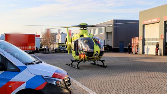 Brand bij bedrijf, persoon met spoed naar ziekenhuis