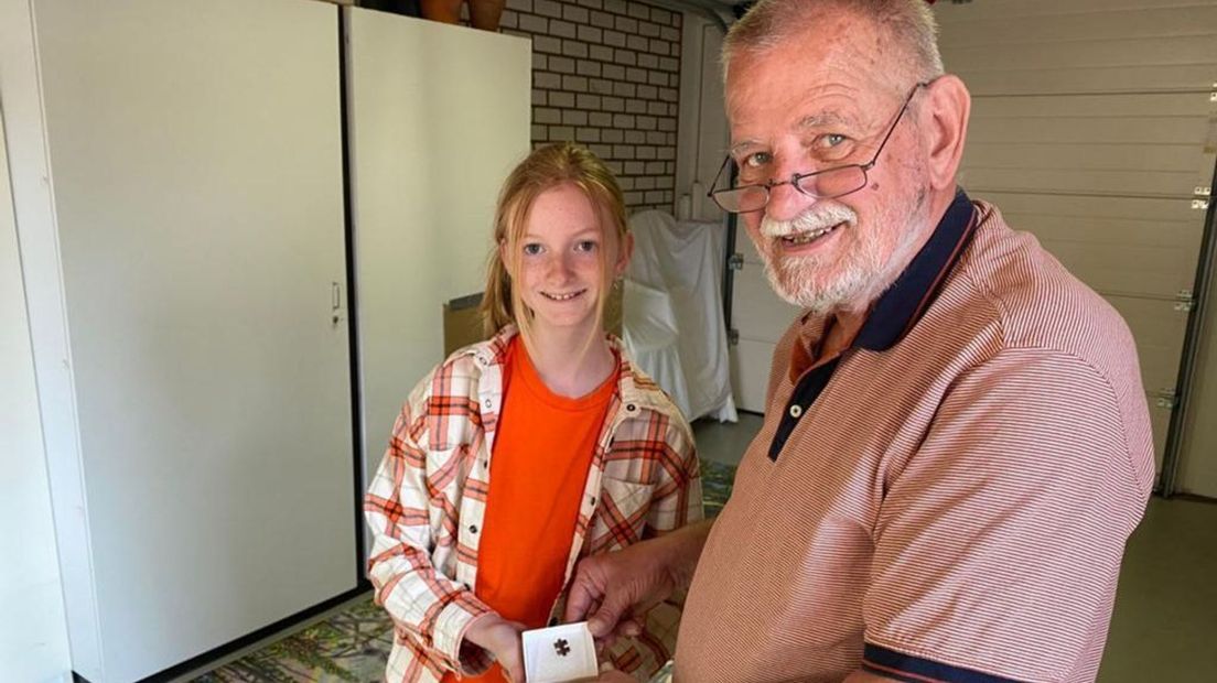 Jan Jonkvorst samen met zijn kleindochter Quinty en het laatste puzzelstukje.