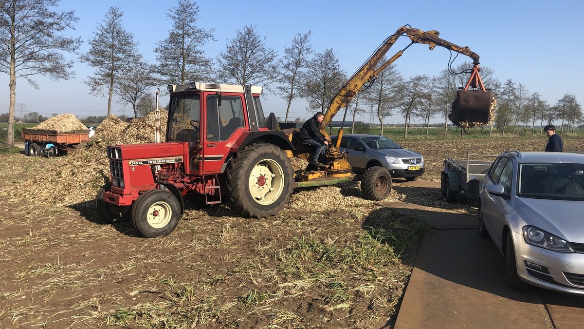 Auto's met karretjes staan in de rij voor versnipperd hout van paasbult