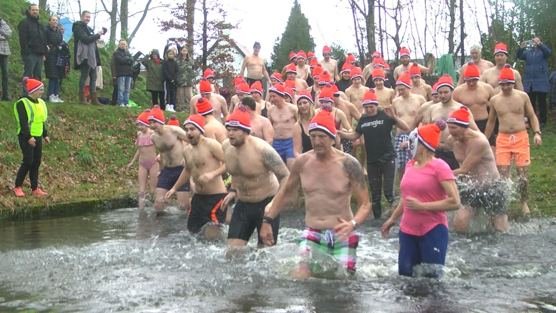 Langzaam wennen aan het koude water van de gracht voor Nieuwjaarsduik Oost Gelre 2023.