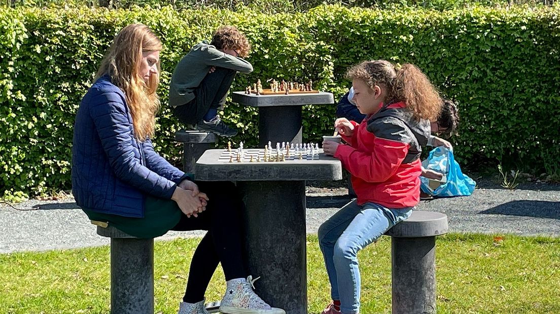 Verschillende jonge meiden in het Máximapark die zich wagen aan een schaakpartijtje.
