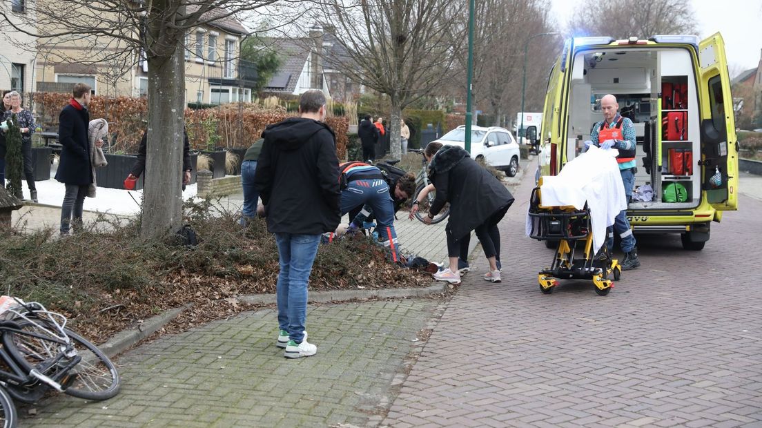 Ambulancepersoneel en omstanders bij het slachtoffer.