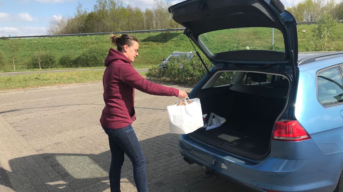 Marleen Brouwer zet zelf in Assen-Noord de menutasjes in de auto van de gasten vanwege de veilige afstand (Rechten: RTV Drenthe / Margriet Benak)