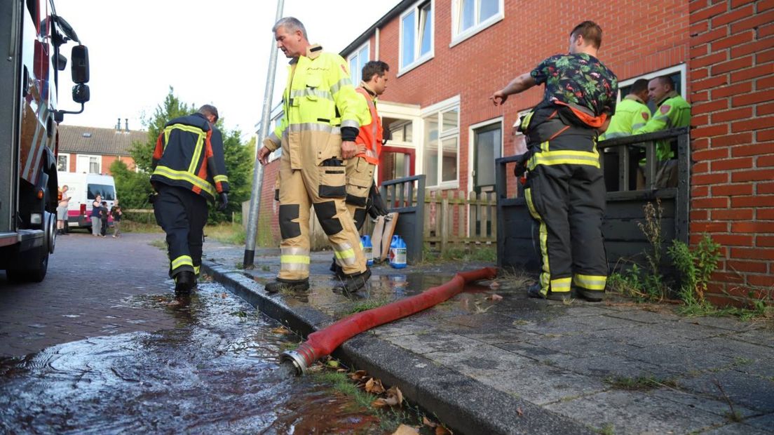 De brandweer helpt mee om het water uit de woningen in Hoogezand te pompen
