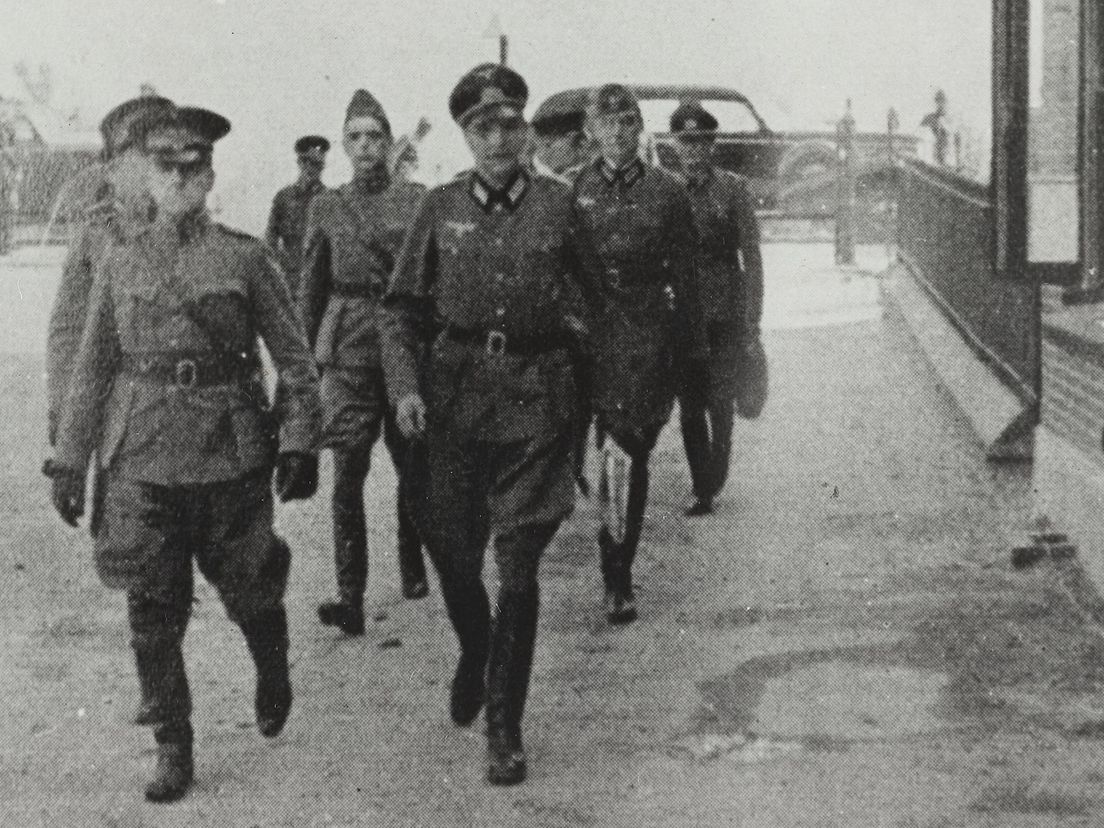 De aankomst van de Nederlandse onderhandelingsdelegatie in Rijsoord. Rechts in beeld de school.
