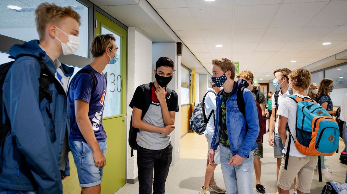 Middelbare scholieren met mondkapjes op in school
