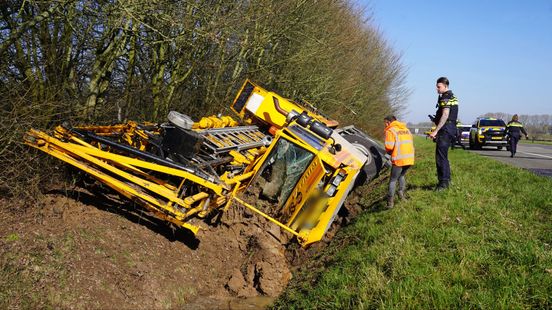 Hijskraan belandt in greppel, bestuurder bevrijd