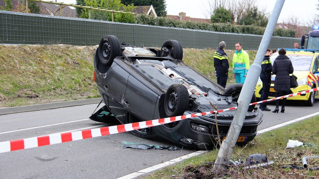 Auto op z'n kop na botsing met lantaarnpaal