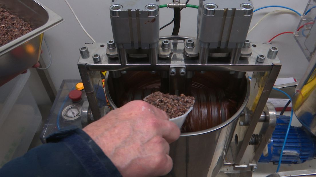 Henk doet cacao in de melangeur.