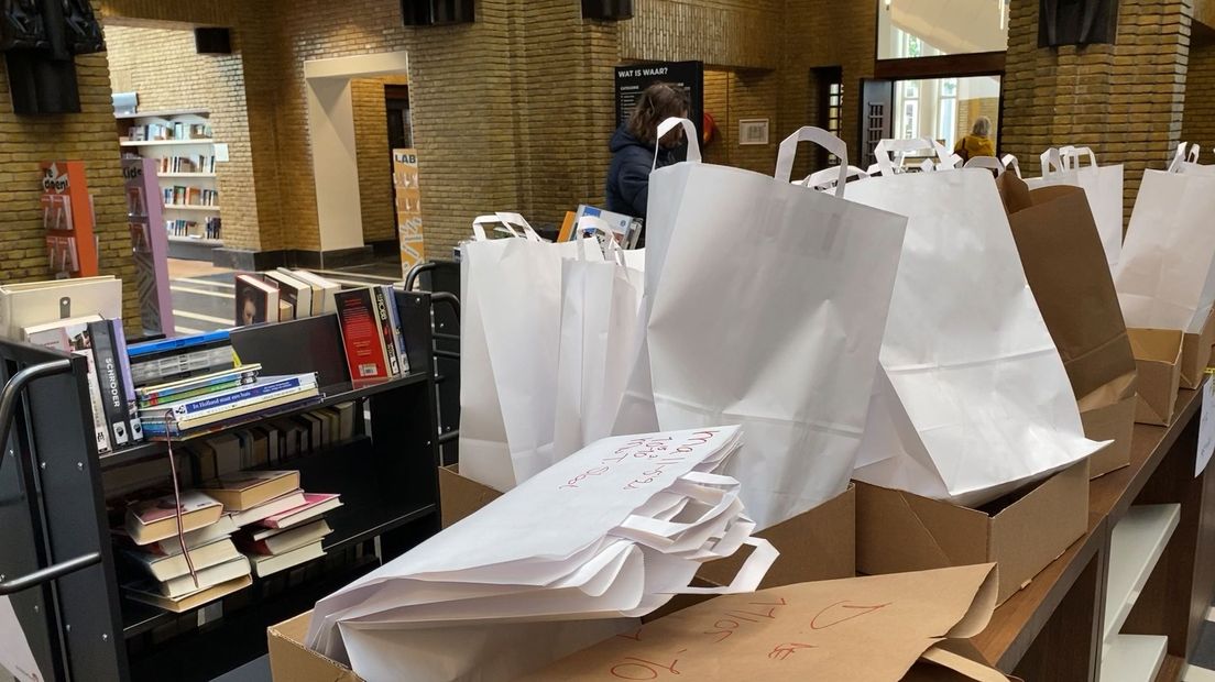 Tassen met boeken staan klaar voor de leden van de bibliotheek