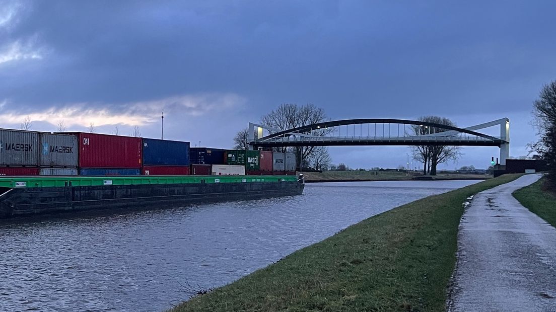 Een schip vaart richting de omhoogstaande Dorkwerderbrug