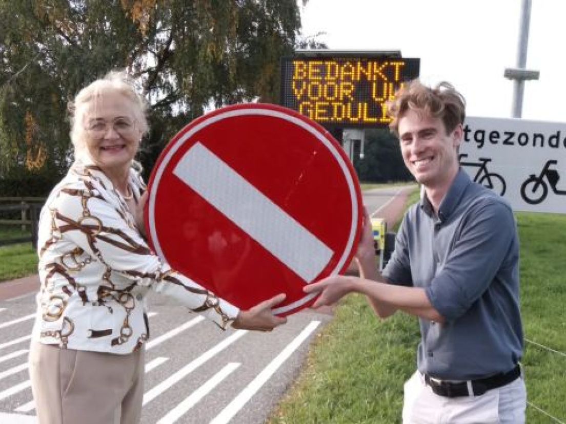 Wethouder Jeanette Derksen haalt een verbodsbord weg.