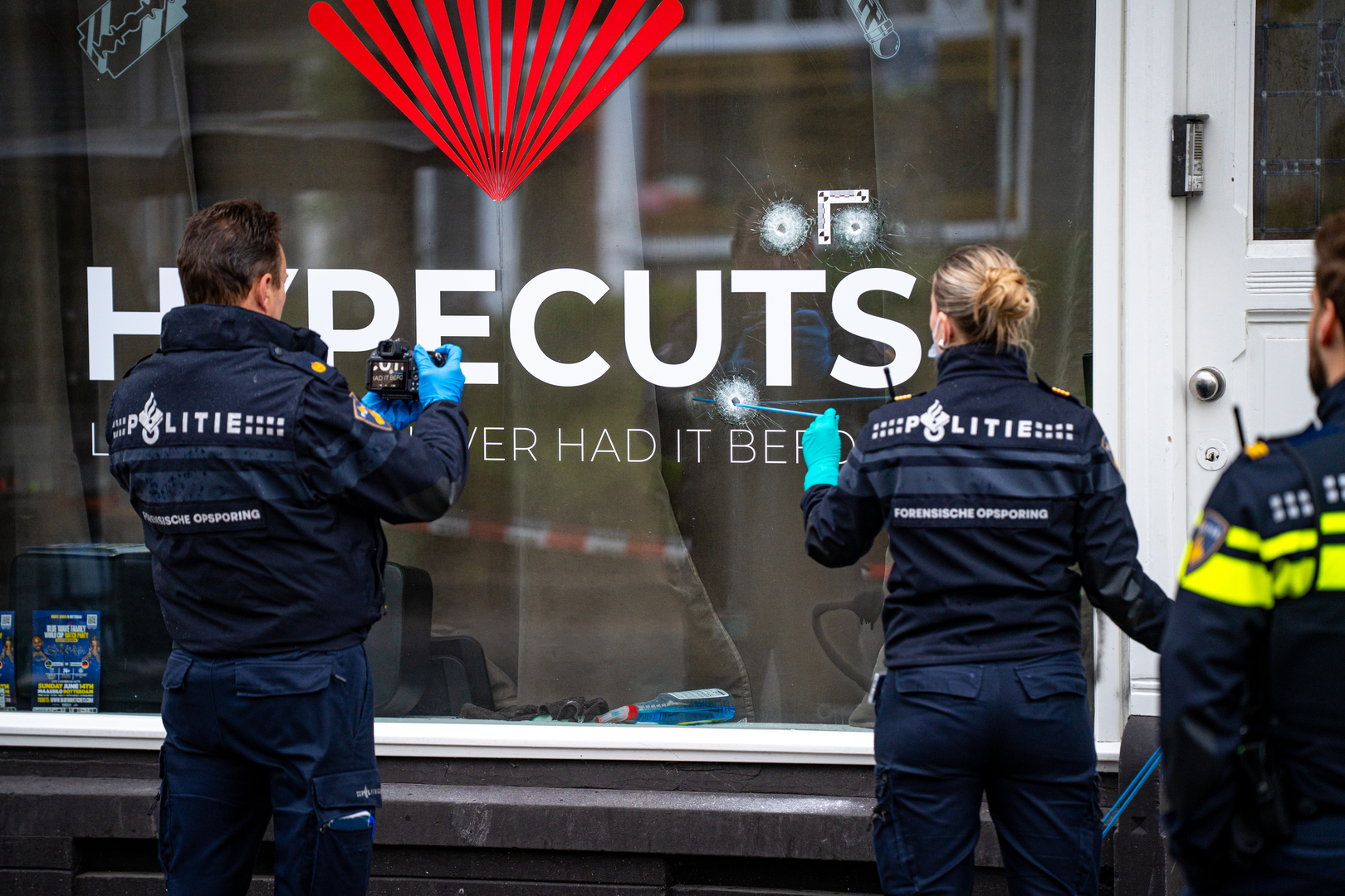 De politie doet onderzoek bij de beschoten kapperszaak.