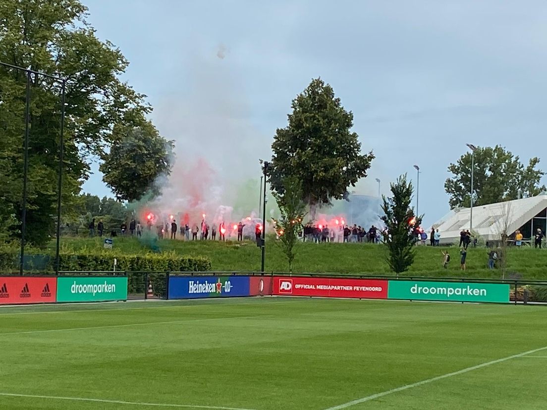 Feyenoordfans verwelkomen selectie met fakkels vanaf dijk