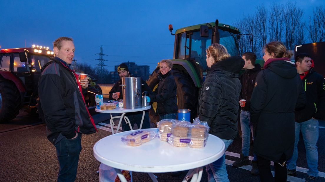 Boeren drinken koffie en eten koeken tijdens hun protestactie op de snelwegen