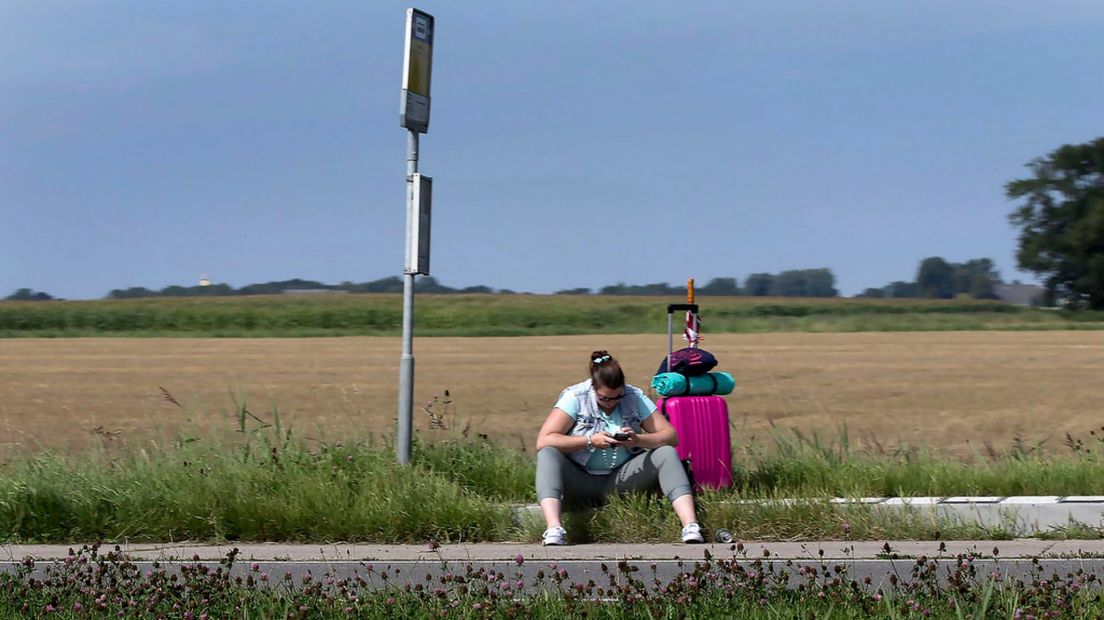 Een vrouw wacht in Leens op de bus