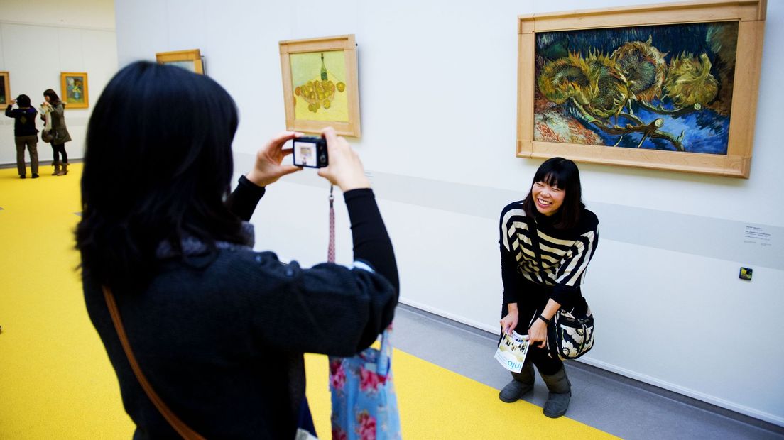 Een bezoeker bij de Vier uitgebloeide zonnebloemen van Van Gogh.