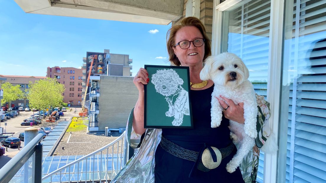 Trees Hijman met haar hond Joep en het schilderij dat op de flatmuur komt