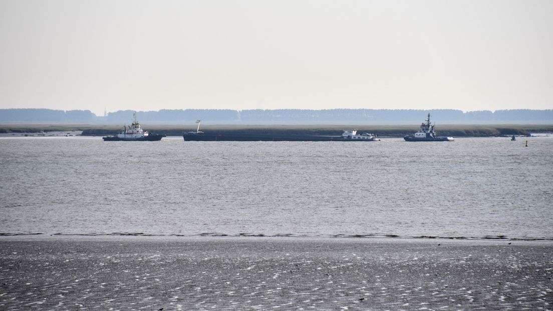 Sleepboten bij gestrand binnenvaartschip op Westerschelde