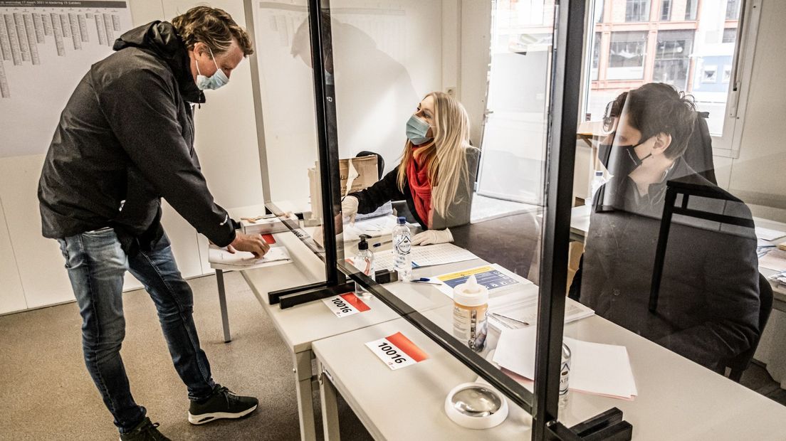 Een man brengt op het station van Leiden zijn stem uit