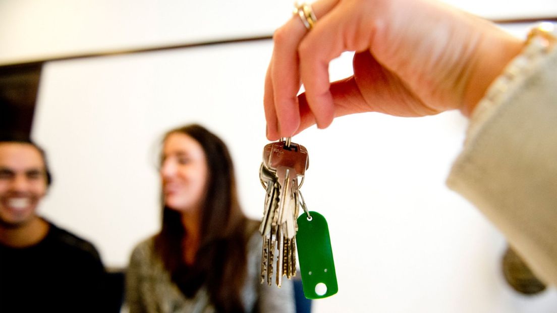 Een stel neemt de sleutels van hun nieuwe huis in ontvangst.