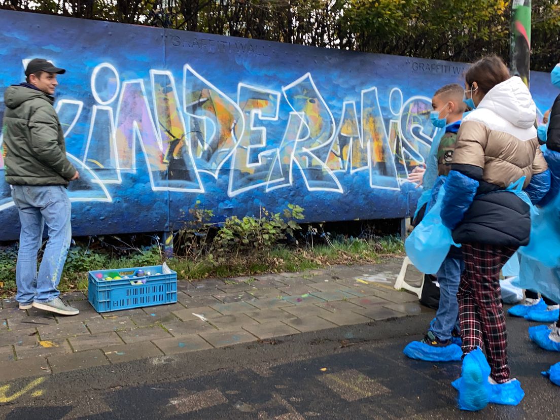 Kinderen maken graffitibord tegen kindermishandeling