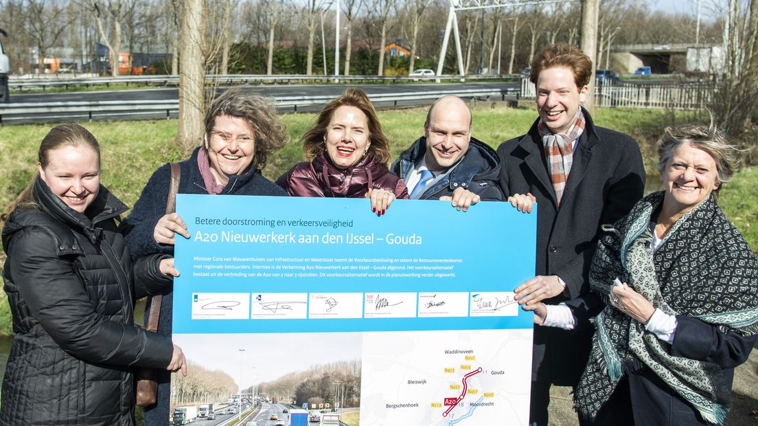 Minister Cora van Nieuwenhuizen (derde van links) brengt een bezoek aan het bekende fileknelpunt.
