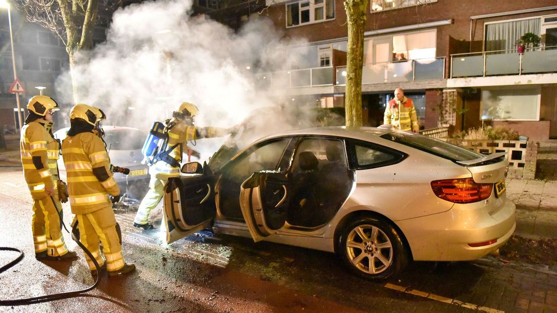 Brandweermannen bij de uitgebrande BMW in Overvecht.