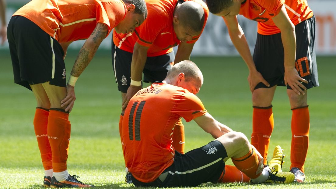 Gregory van der Wiel, Nigel de Jong en Ibrahim Afellay buigen zich over de geblesseerde Arjen Robben