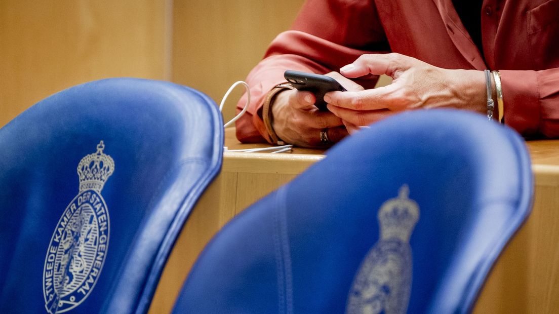Een Tweede Kamerlid is bezig met de mobiele telefoon