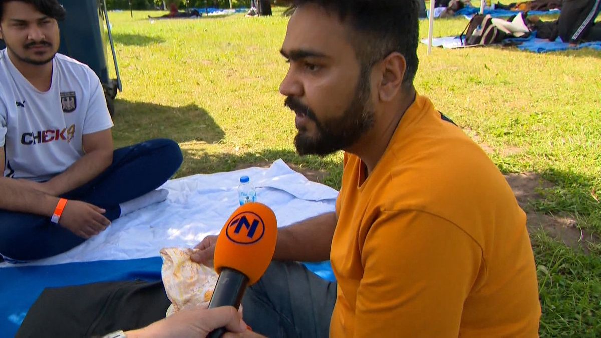 Asielzoekers wachten in de brandende zon in Ter Apel