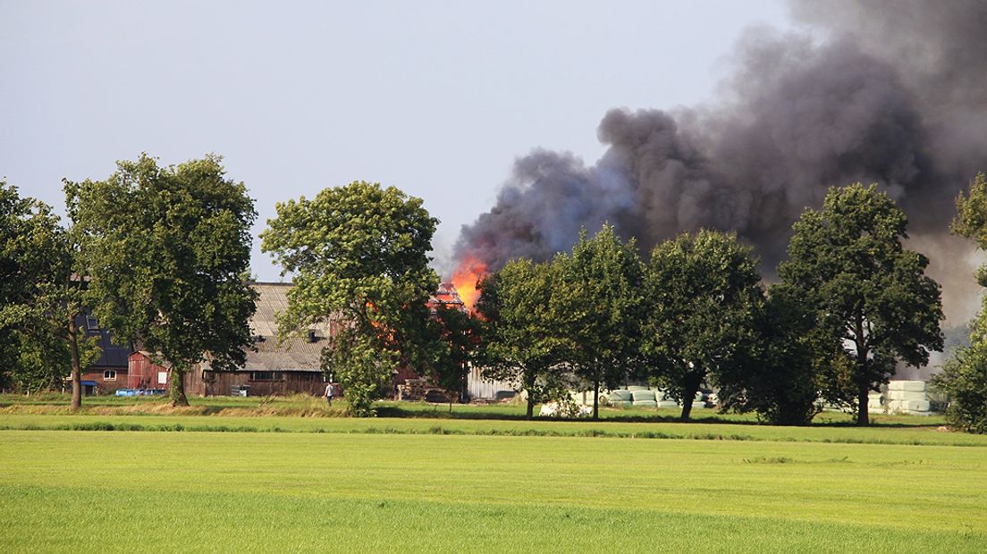 De vlammen slaan inmiddels uit het dak.