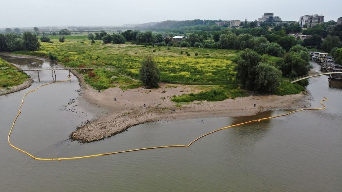 Met een 'olieboom' wordt voorkomen dat de verontreiniging zich via het water verspreidt.