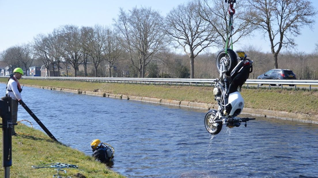 Duikers hielpen om de motor uit het water te krijgen