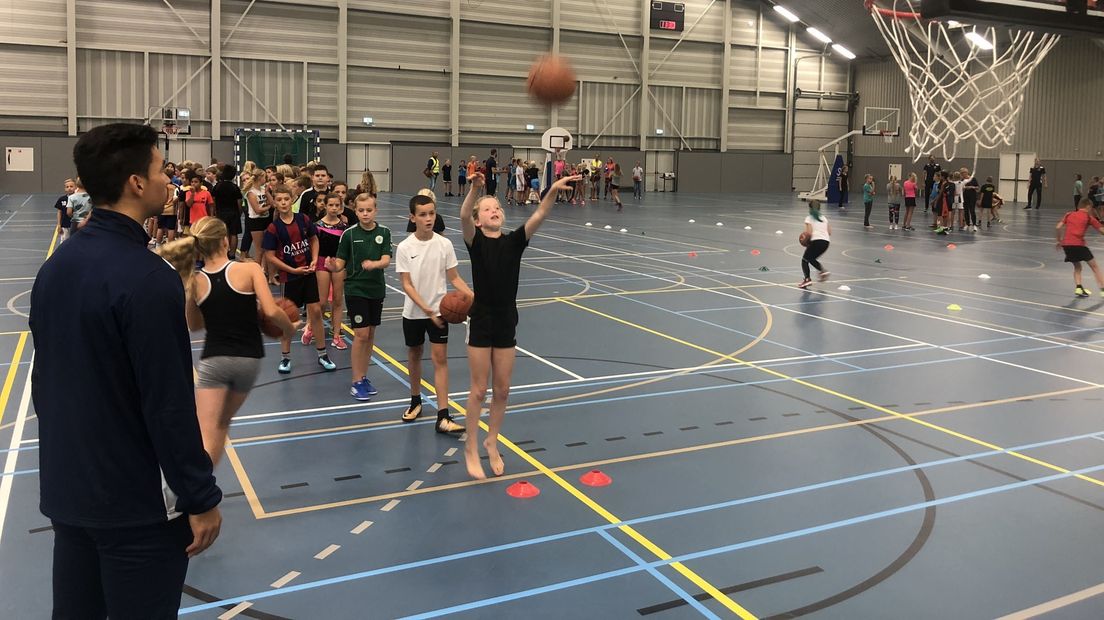 De kinderen leren dribbelen en schieten